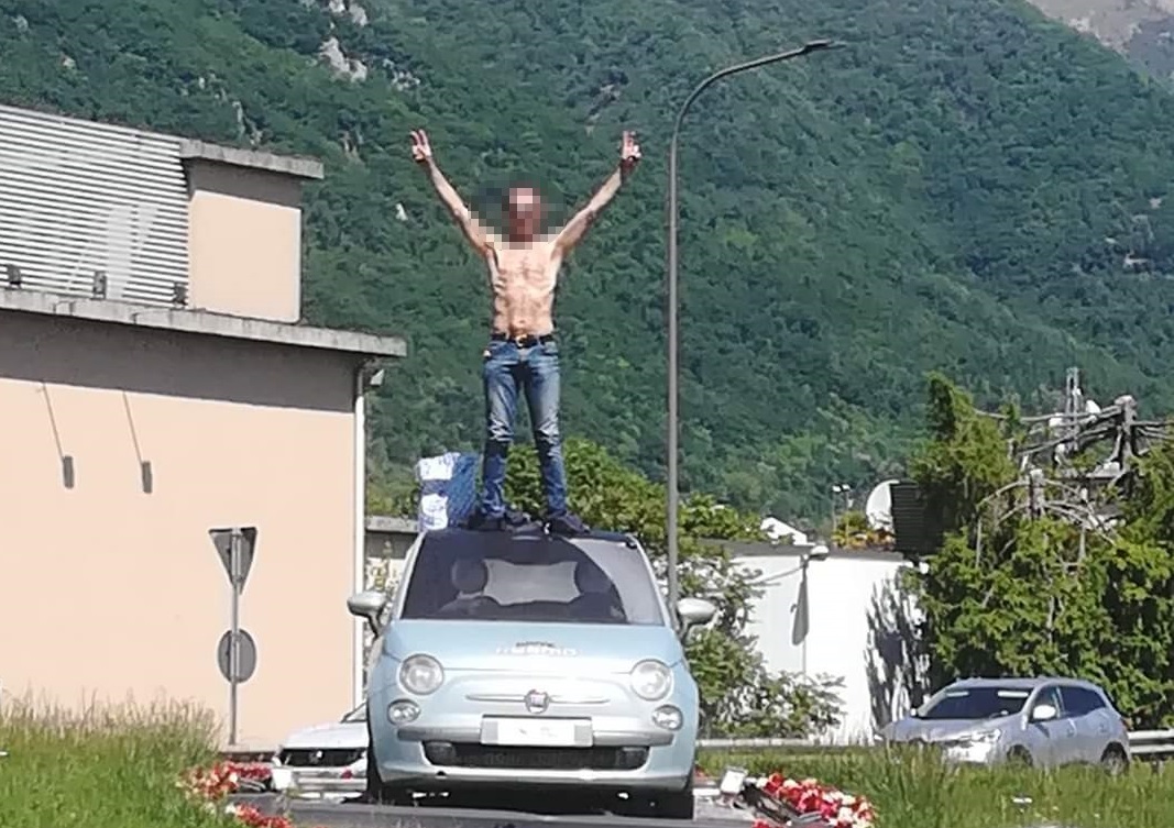 Sopra l’auto a petto nudo: “Questo è il centro del mondo”