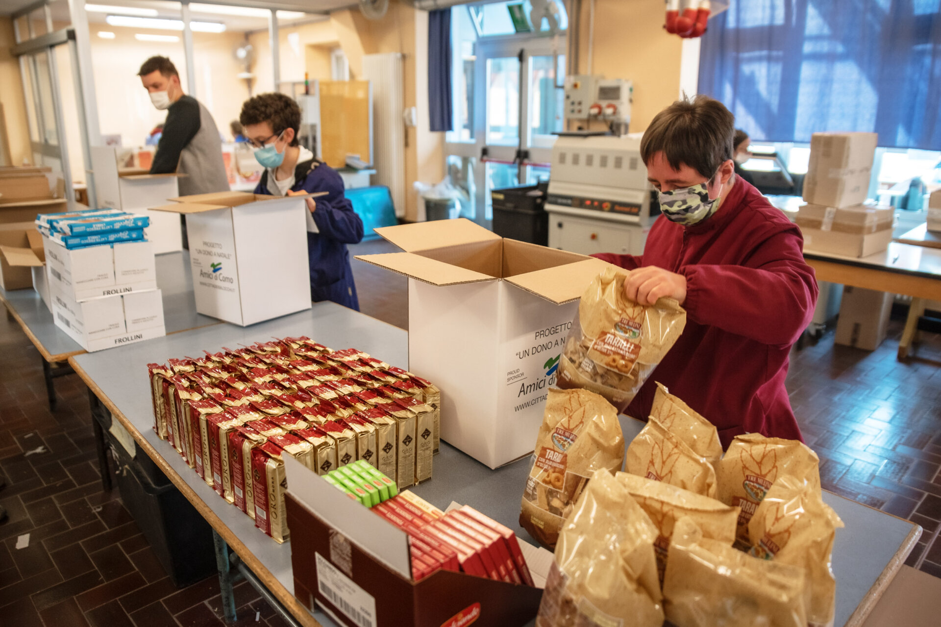 Como Nostra Famiglia di via Zezio confezionamento dei pacchi viveri per le famiglie bisognose del progetto "Un dono a Natale" di AMici di COmo e CIttà dei Balocchi