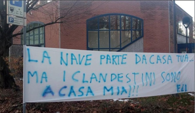 Lo striscione di Fratelli d’Italia Fino Mornasco contro la mostra sui migranti