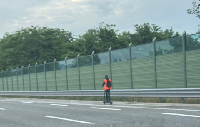 Viaggia su un monopattino in autostrada