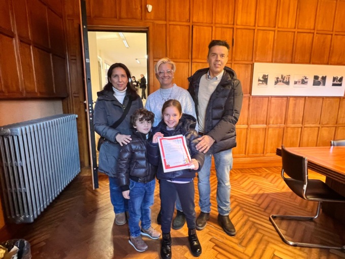 L’assessore consegna la lettera e il regalo mandati da Babbo Natale a due fratellini di Erba